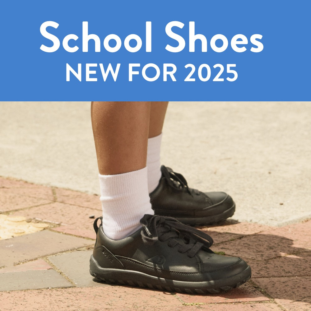 Black school shoes worn with white socks on a paved surface, with 'School Shoes NEW FOR 2025' text at the top.