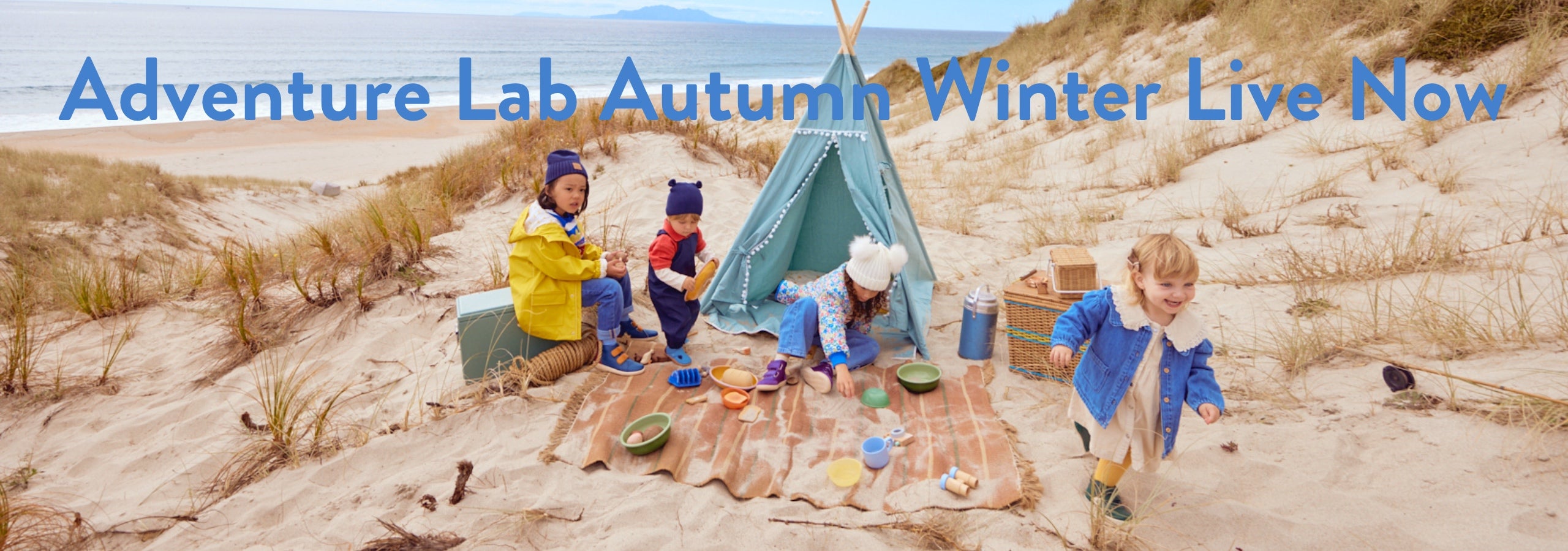 Kids with a tent playing on a beach on a cloudy day