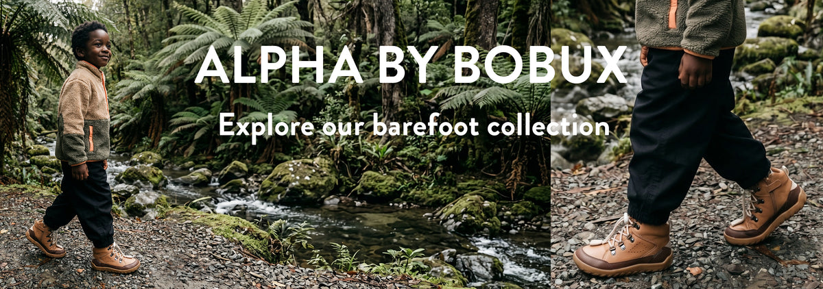 A child outdoors near a stream wearing tan lace-up barefoot-style boots. Large text reads 'ALPHA BY BOBUX' and 'Explore our barefoot collection.