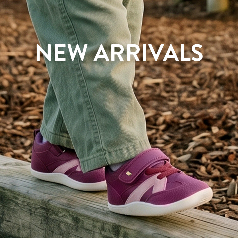 A person wearing olive green pants and purple Reebok sneakers standing on a wooden board outdoors on a bed of brown leaves, with 'NEW ARRIVALS' text overlaid at the top.